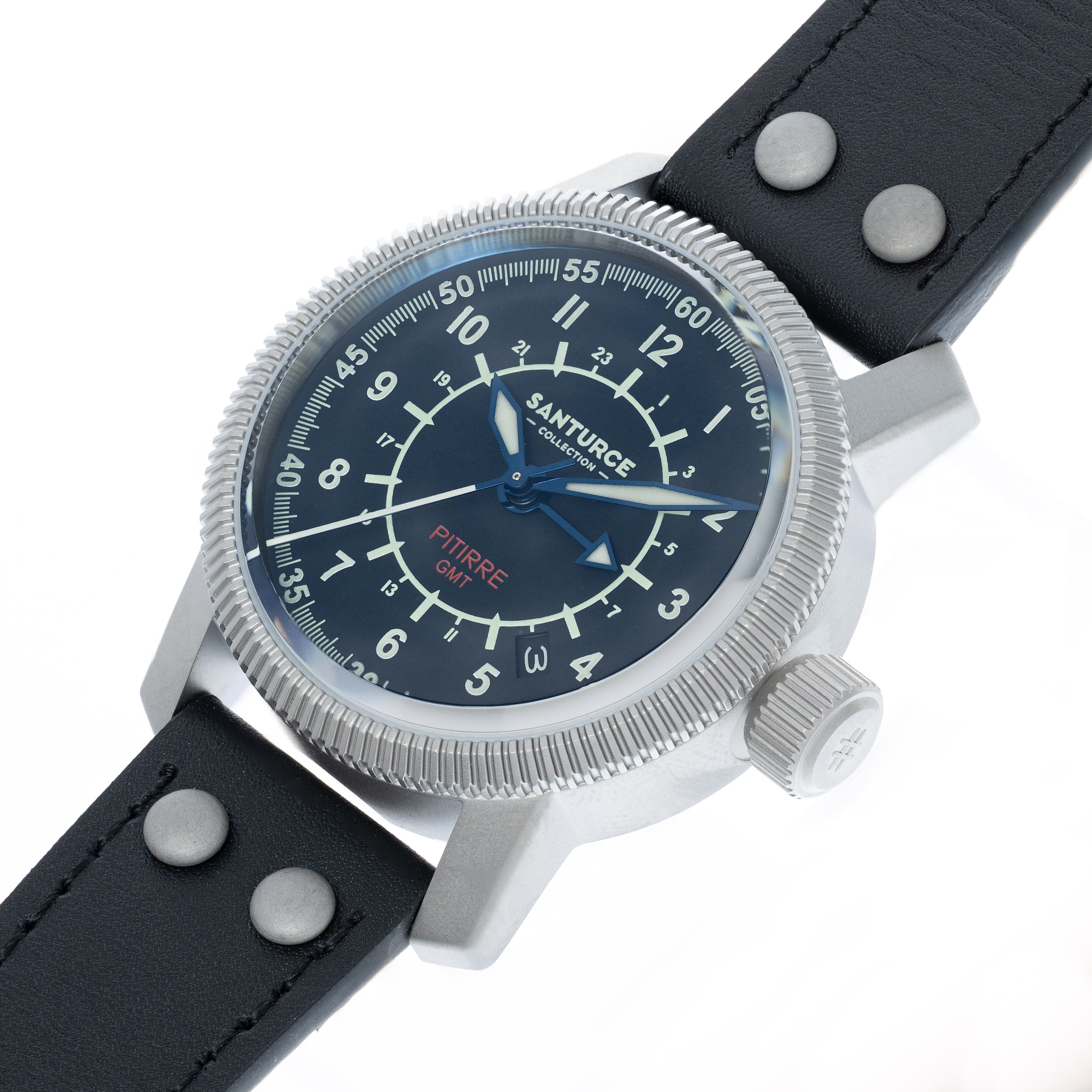 A close-up shot of a Santurce Pierre GMT watch with a silver stainless steel case, a dark blue dial with white Arabic numerals, and a black leather strap with silver rivets, set against a plain white background.
